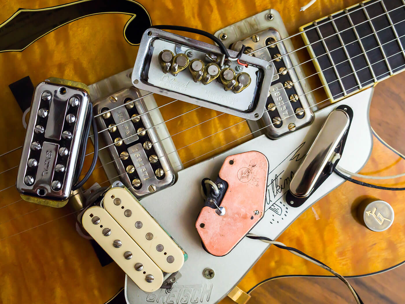 Step-by-step pickup modification on a vintage-style guitar.