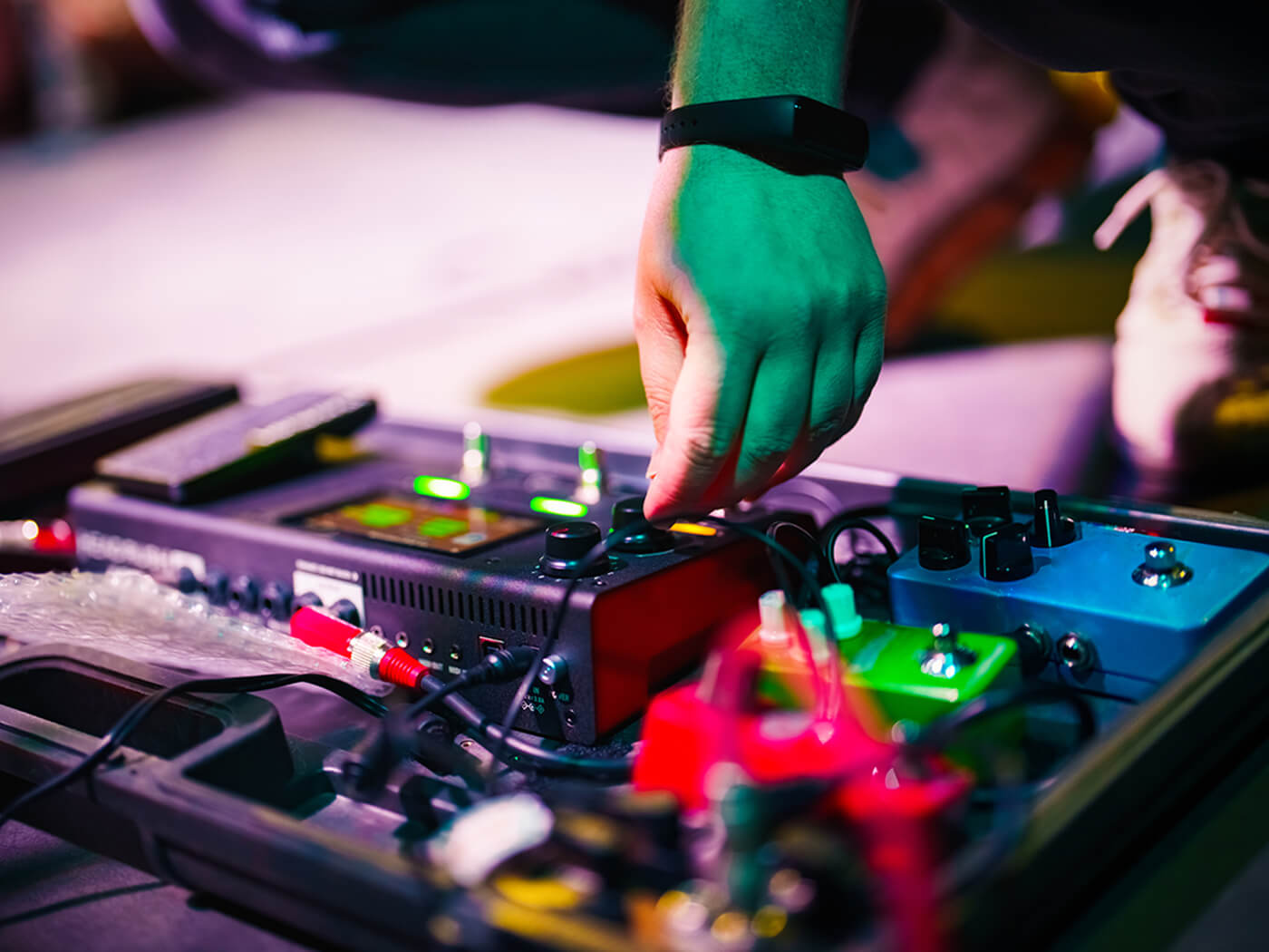 Musician demonstrating guitar pedal adjustments during a live session